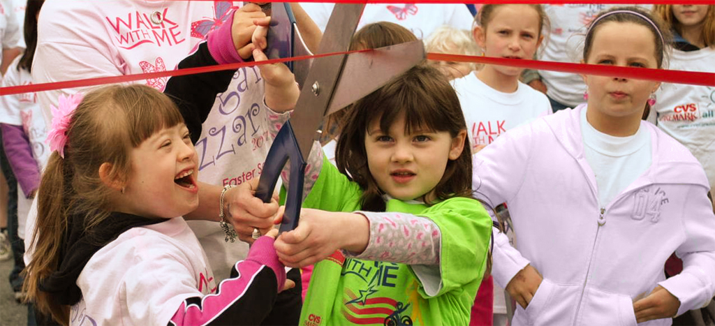 Two kids cutting a ribbon at Walk With Me
